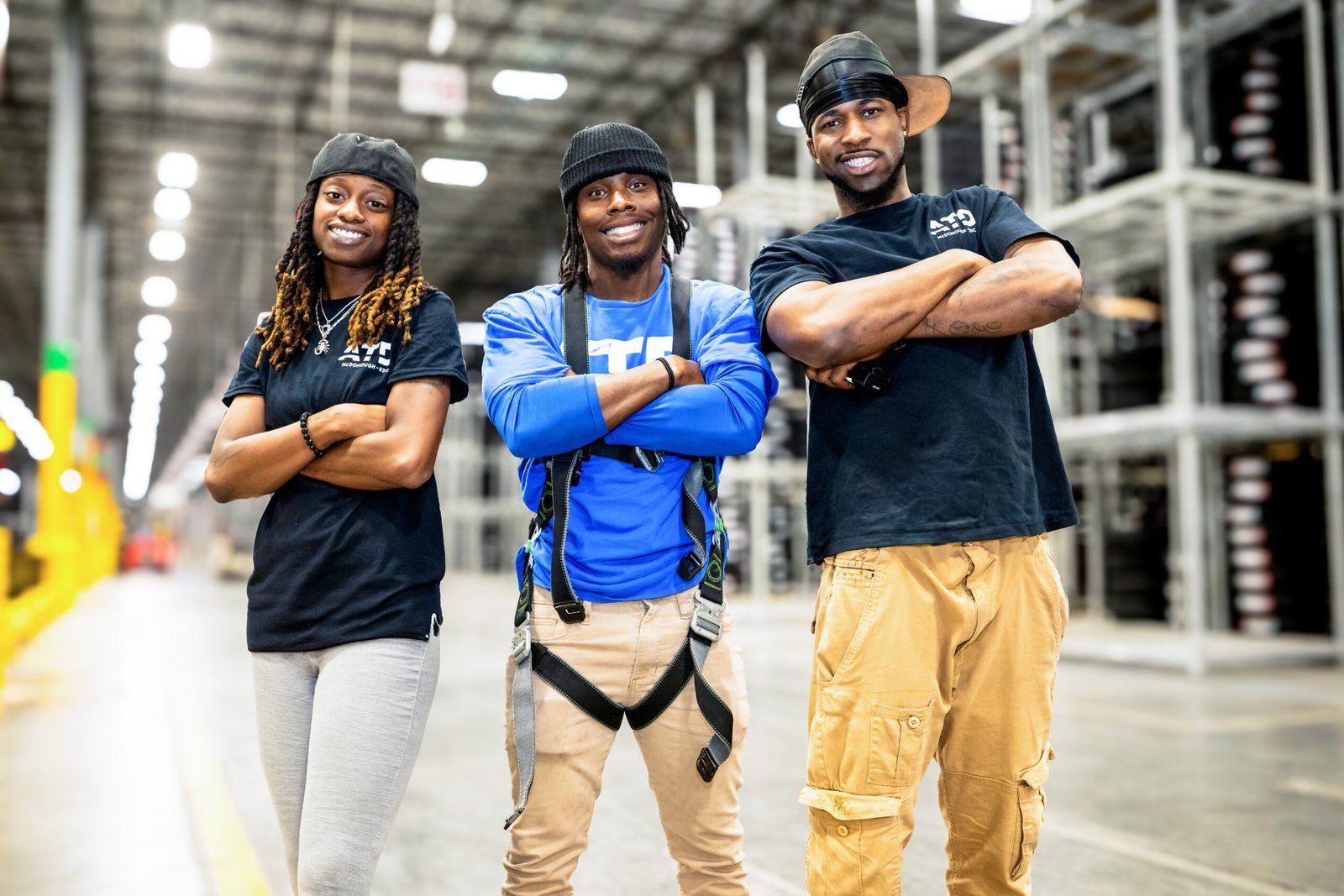 Three warehouse associates standing together in a distribution center