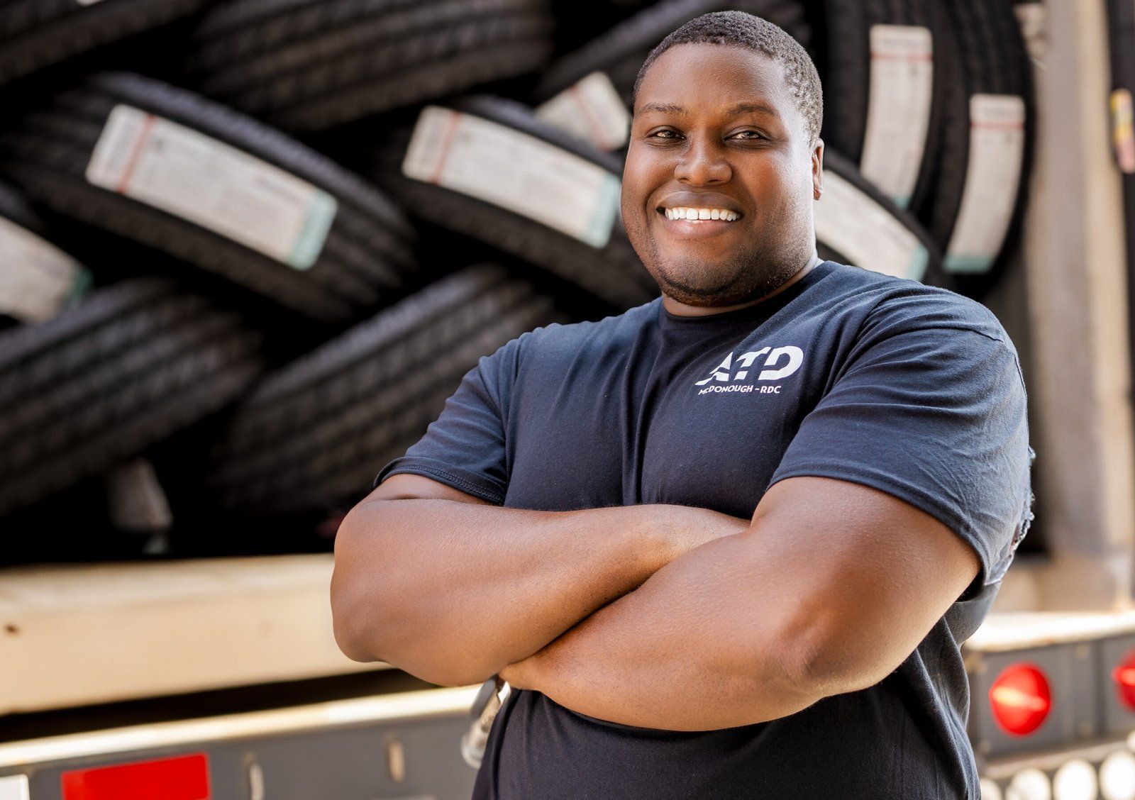 Associate in front of stacked tires