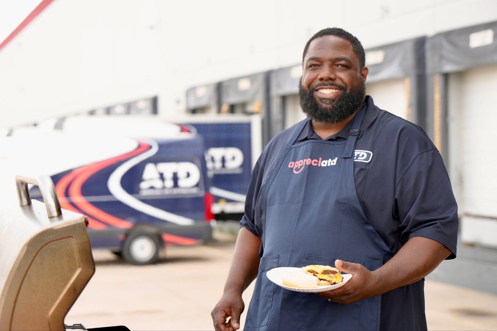 Associate smiling beside a branded delivery truck